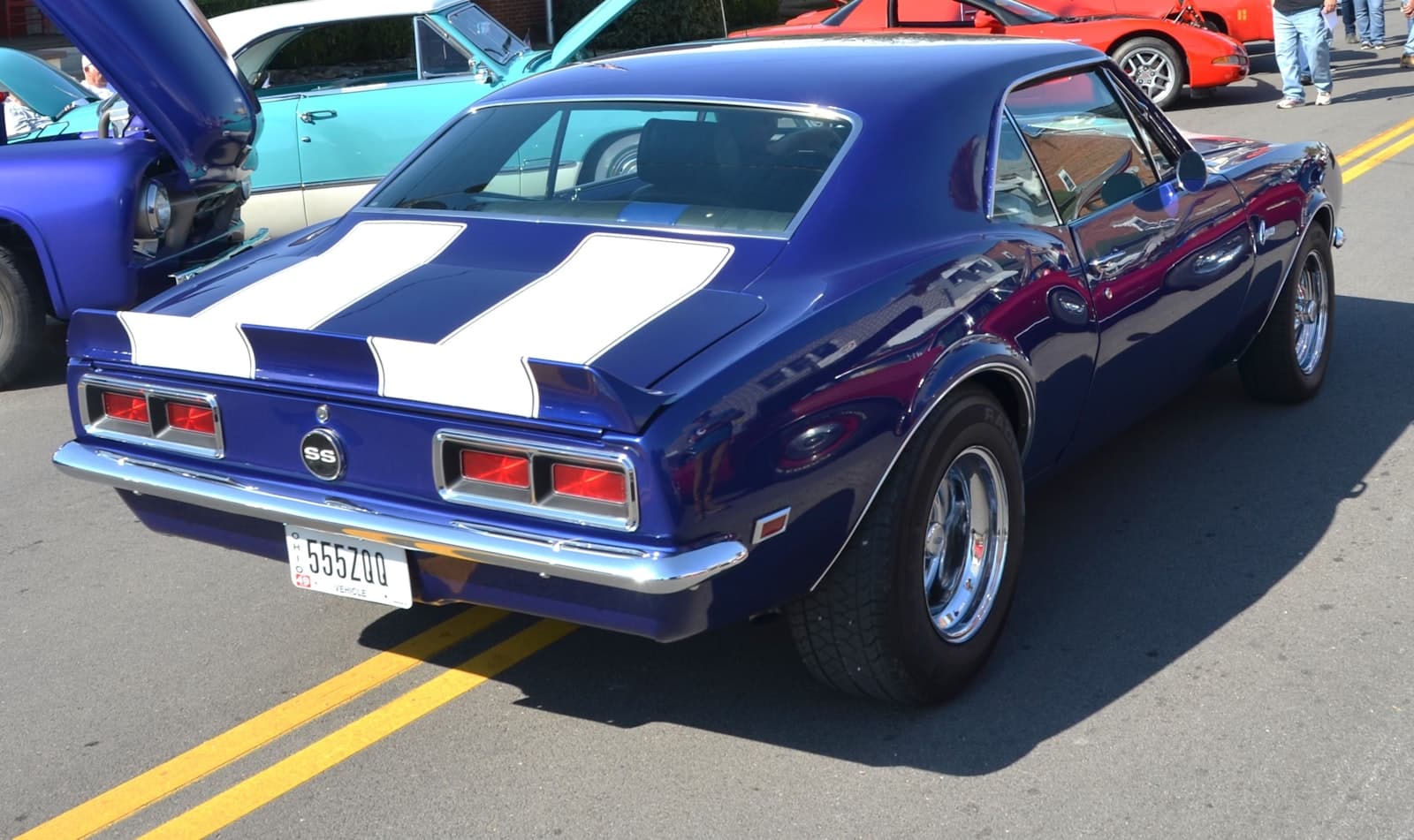 A blue Chevrolet Camaro SS parked in a row of cars at a show